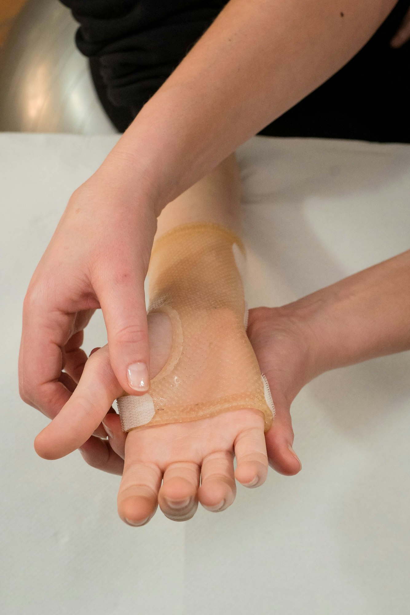 Closeup of a nurse doing physical therapy for a patient's hand recovery