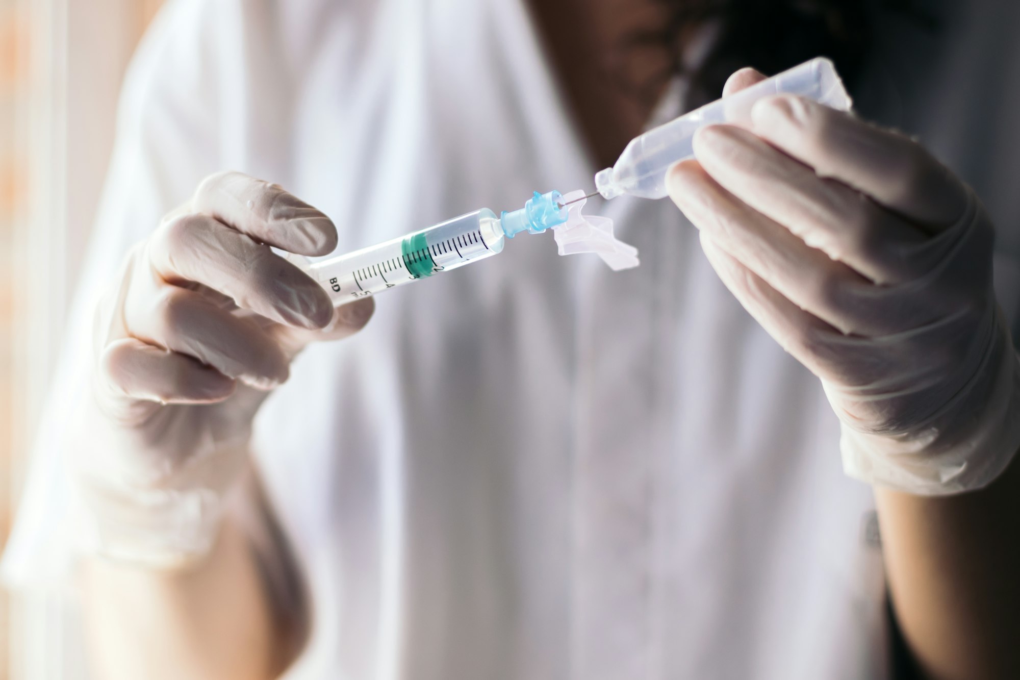 nurse injecting serum into a syringe